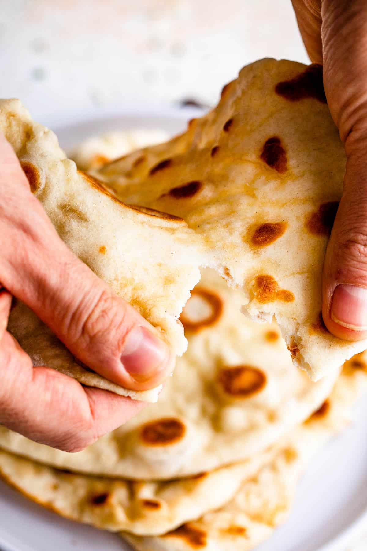 tearing naan bread with hands