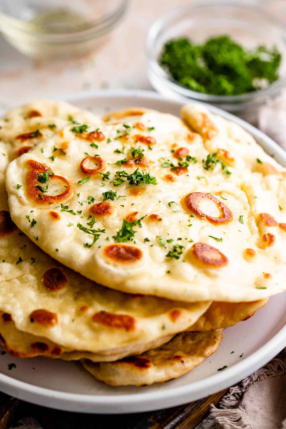 Stacked naan bread served on a plate.