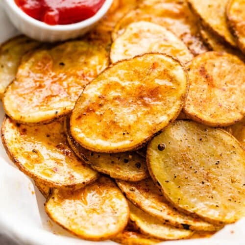 serving air fryer potato chips with a small bowl of ketchup on the side