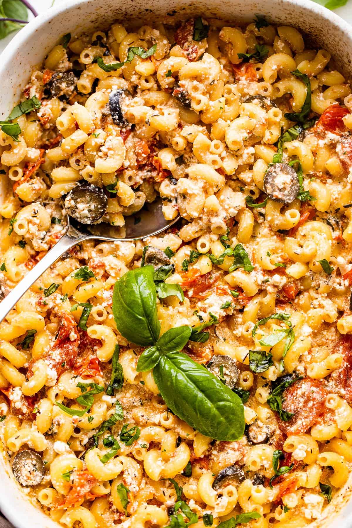 baked feta pasta in a casserole dish with a serving spoon