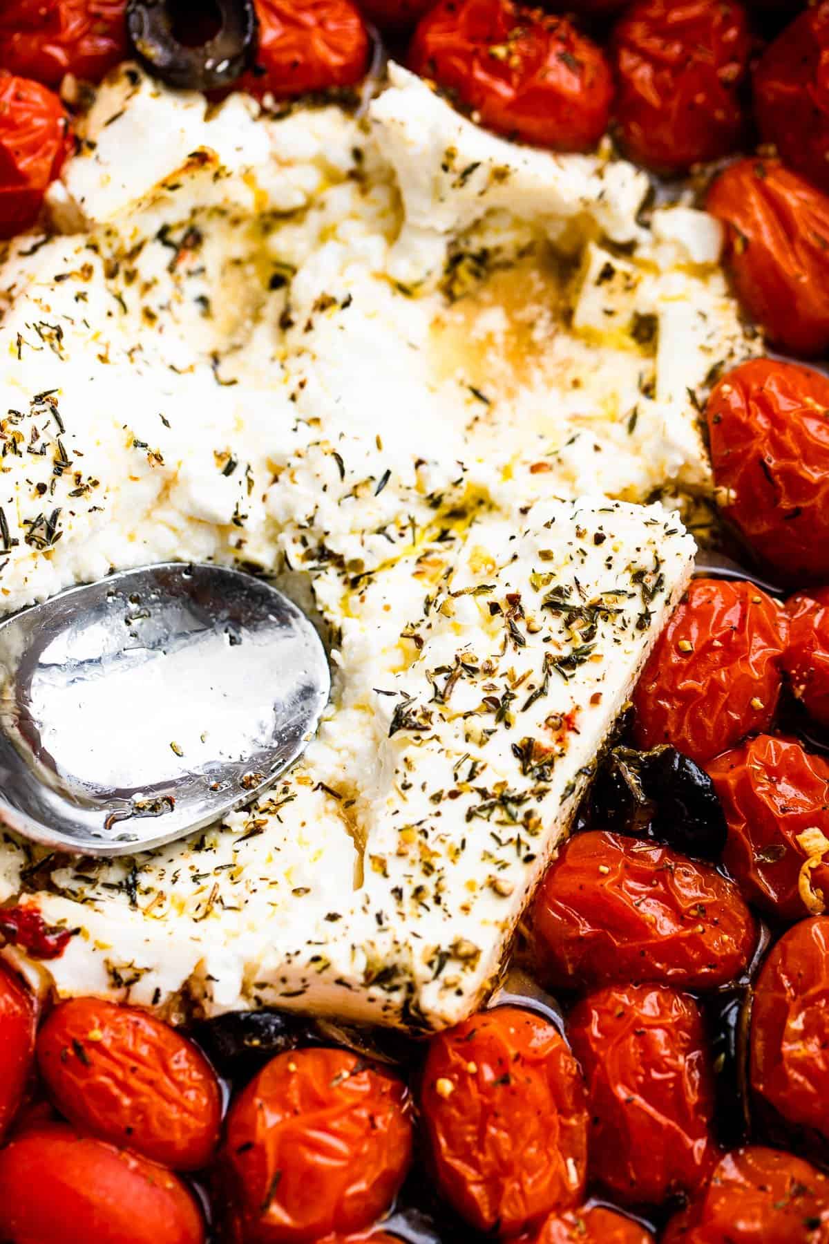 pressing baked feta with the back of a spoon