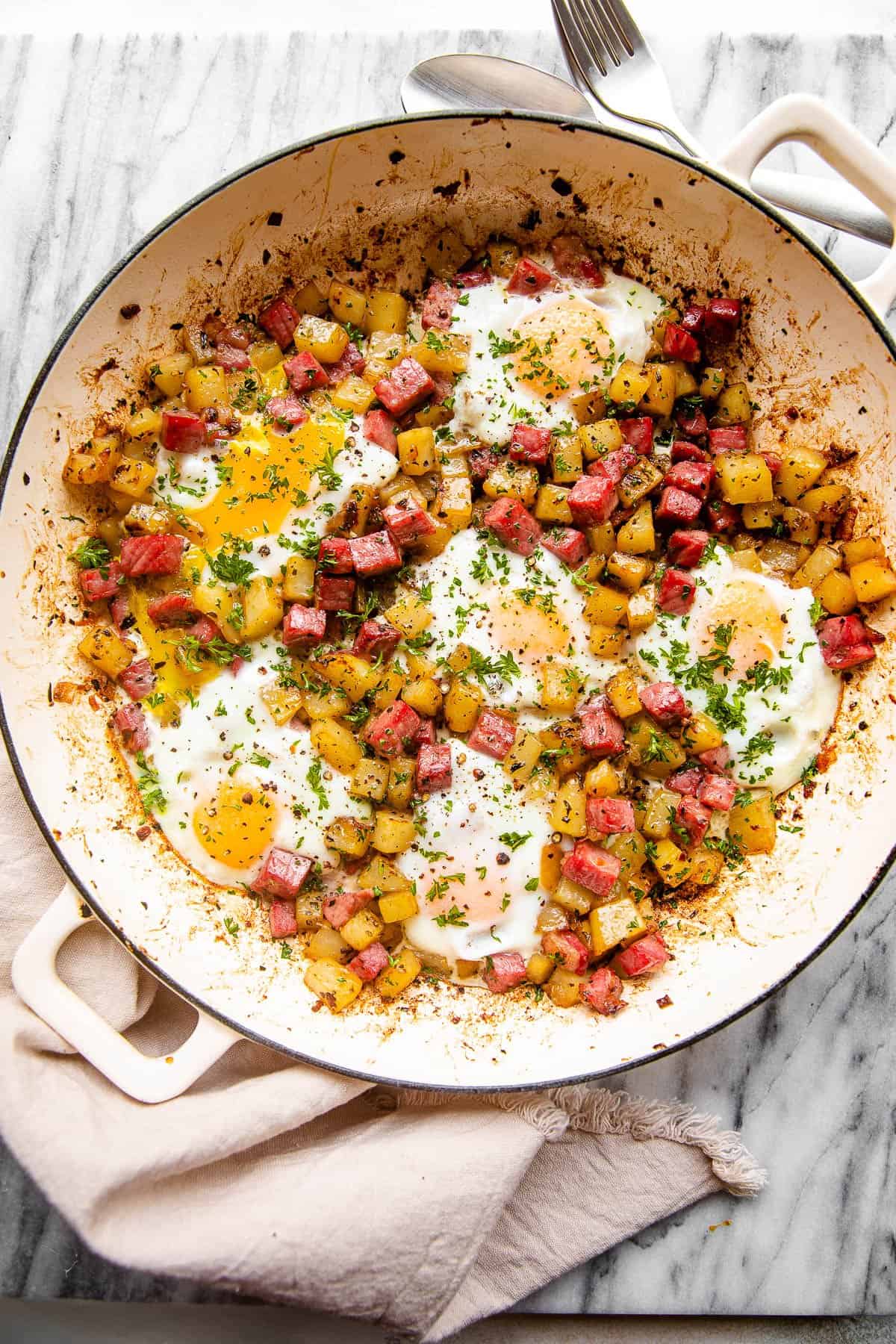 overhead shot of a skillet with corned beef hash with potatoes eggs