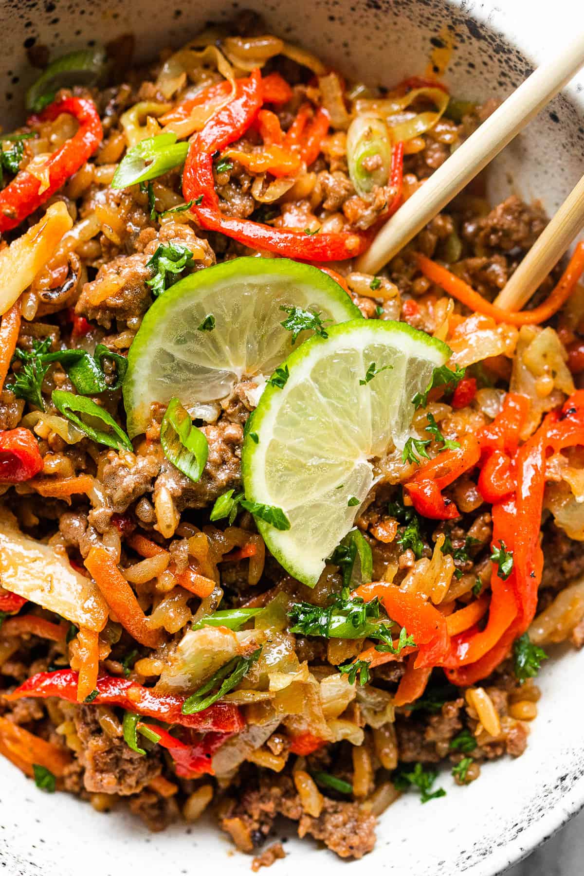 deconstructed egg roll in a bowl served with lime slices and chopsticks