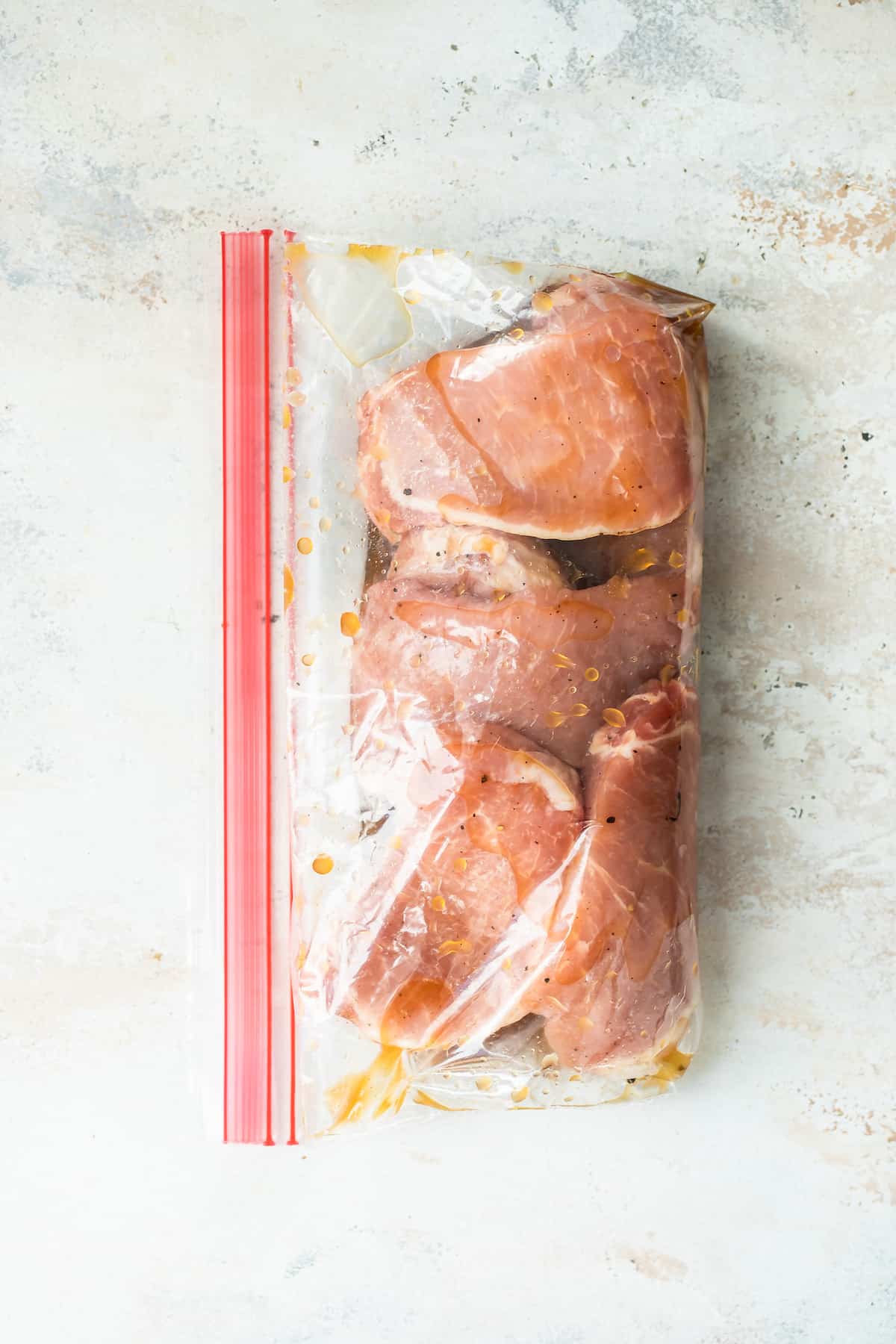 Uncooked Pork Chops Marinating in a Resealable Bag