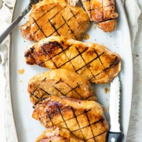 Grilled Pork Chops on a Serving Platter with a Knife and Fork