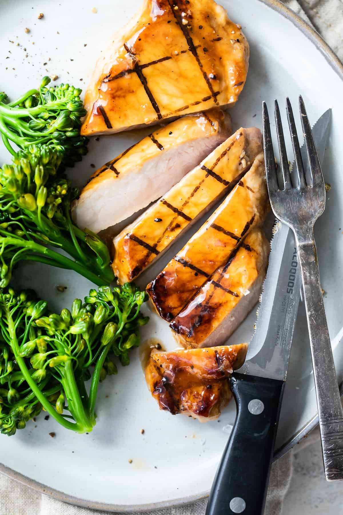 A Sliced Honey Pork Chop on a Plate with a Fork and Knife