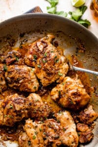 five cooked chicken thighs in a skillet