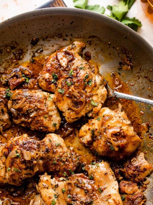 five cooked chicken thighs in a skillet