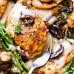 chicken cutlets in creamy madeira sauce with asparagus stalks and sliced mushrooms