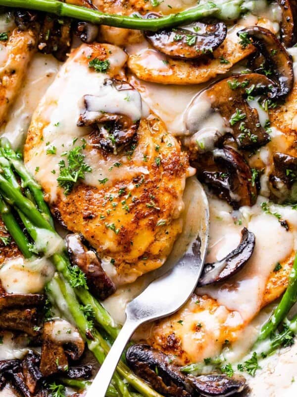 chicken cutlets in creamy madeira sauce with asparagus stalks and sliced mushrooms