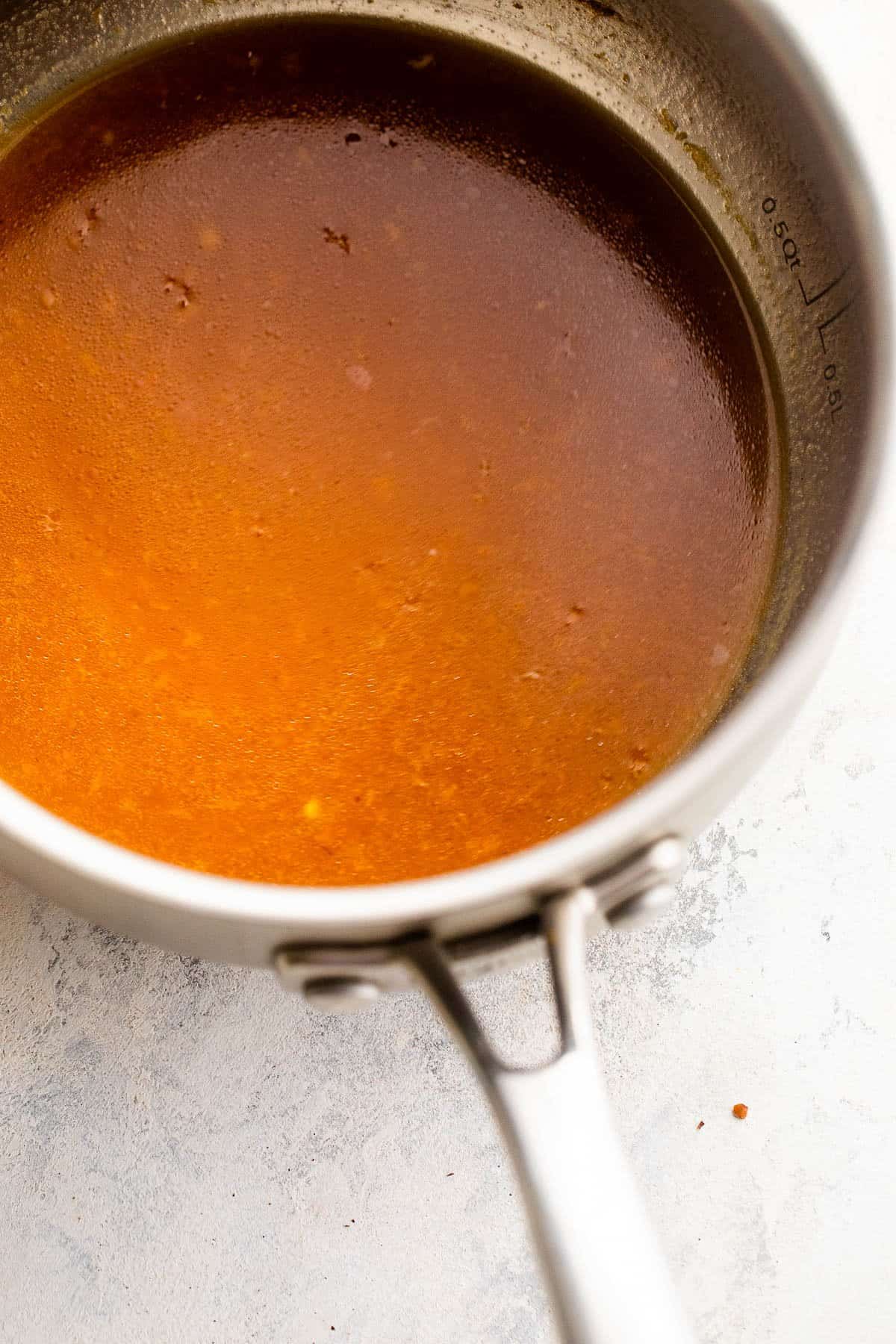 cooking orange sauce in a saucepan