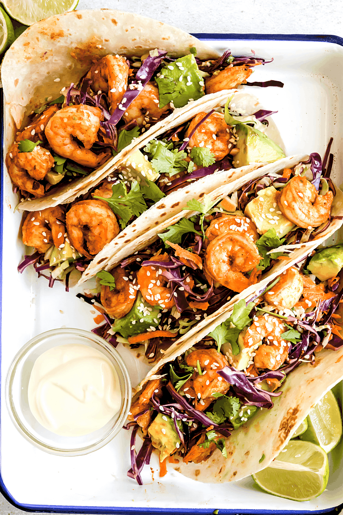 overhead shot of shrimp tacos served on a white tray