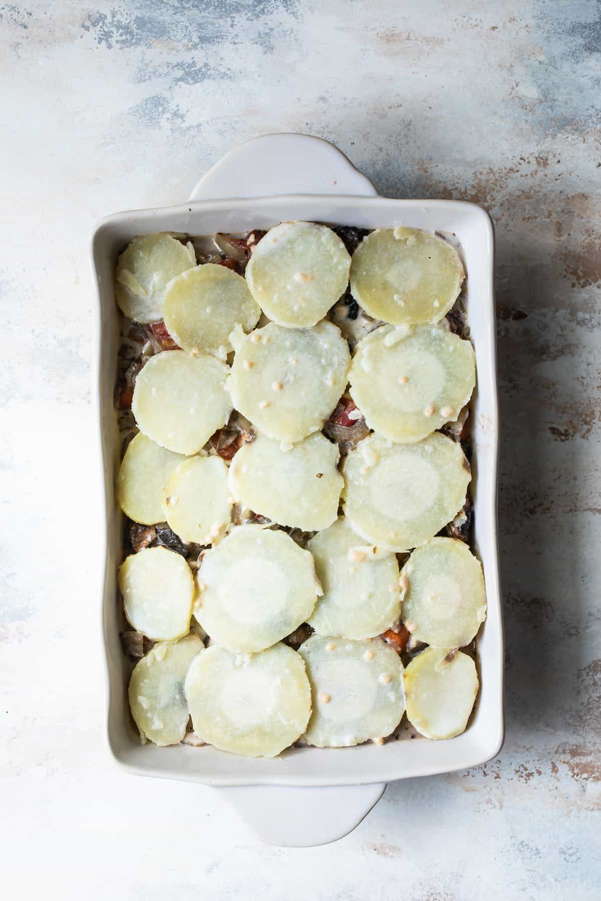 A Layered Pan of Unbaked Moussaka with Potato Slices on Top