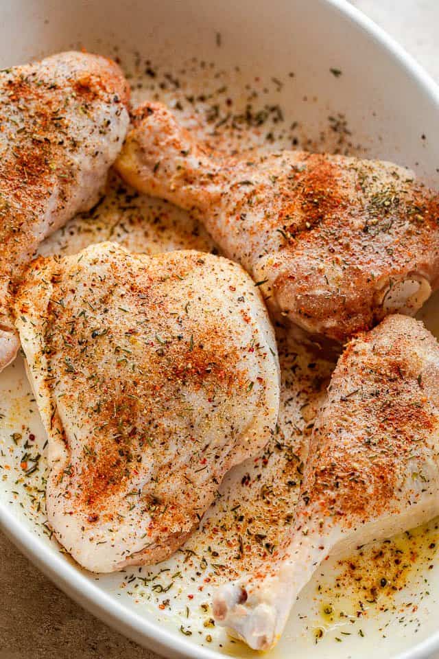 prepping raw chicken pieces in a baking dish