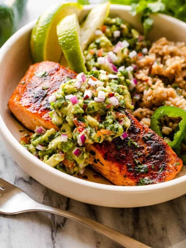 salmon fillet in a bowl atop of rice and served with avocado salsa