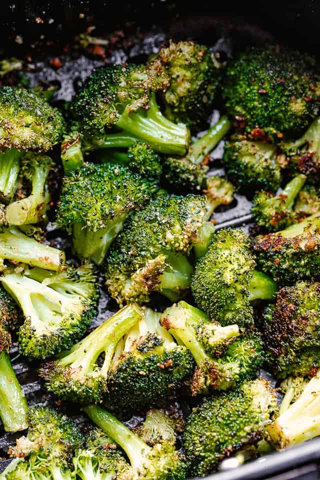 cooked broccoli florets in air fryer basket