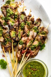 eight Grilled Steak Skewers topped with chimichurri sauce