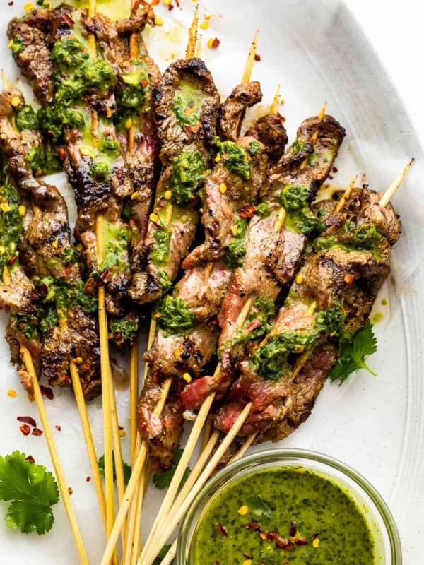 eight Grilled Steak Skewers topped with chimichurri sauce