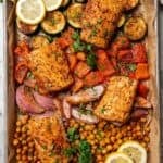 Overhead view of baked mahi mahi with crispy chickpeas and roasted vegetables on a sheet pan.