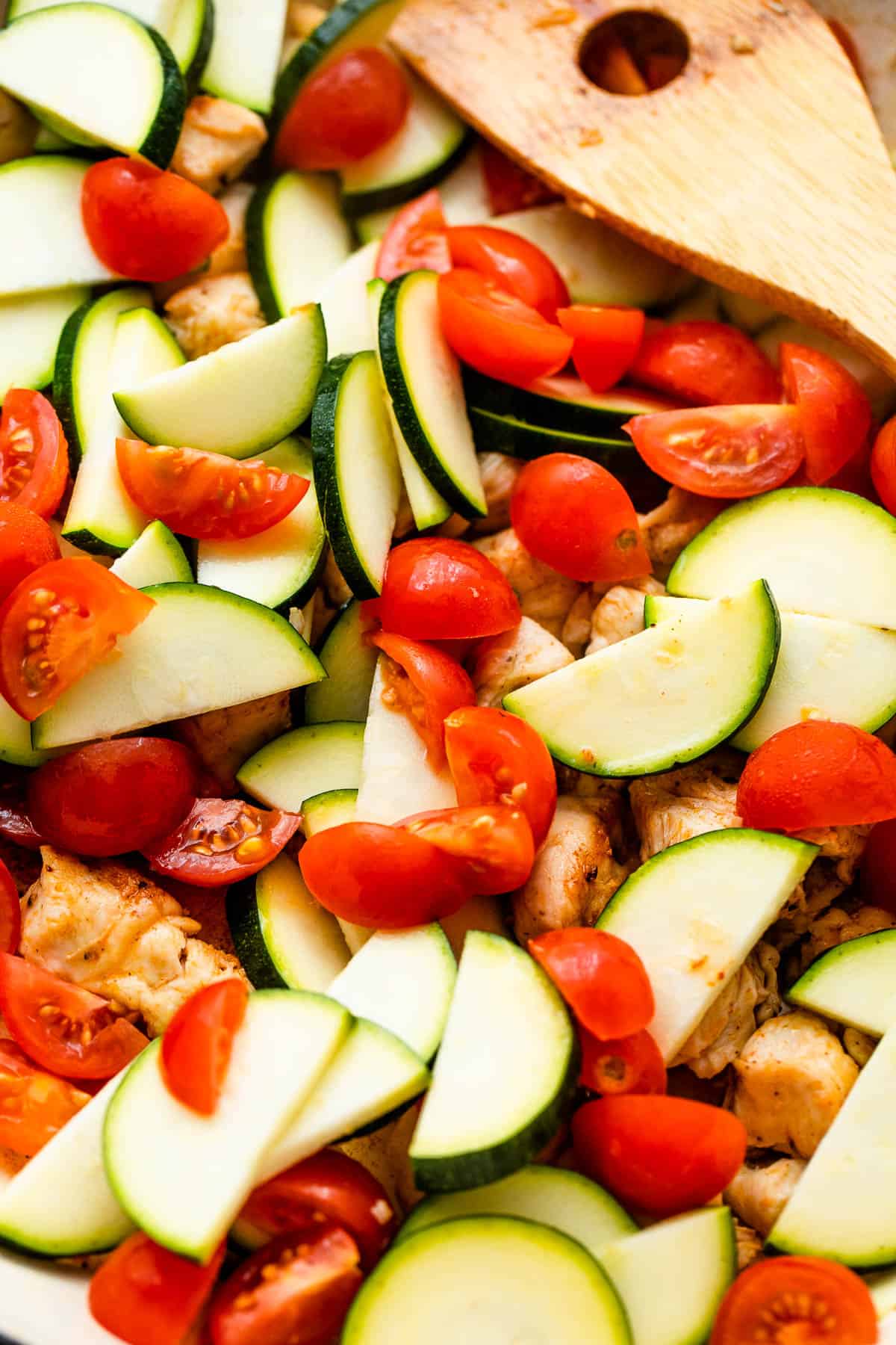 close up photo of zucchini slices and cherry tomatoes