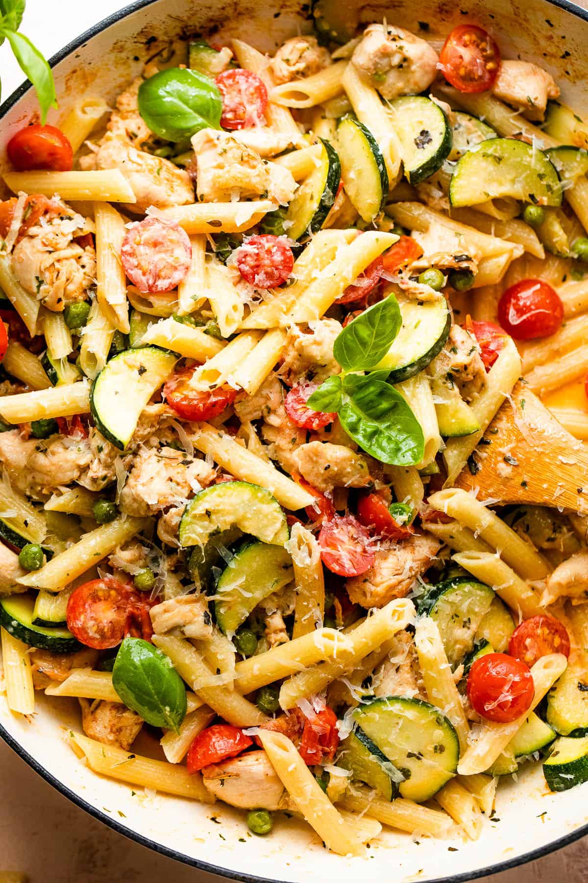 Close-up image of chicken pasta primavera in a skillet.