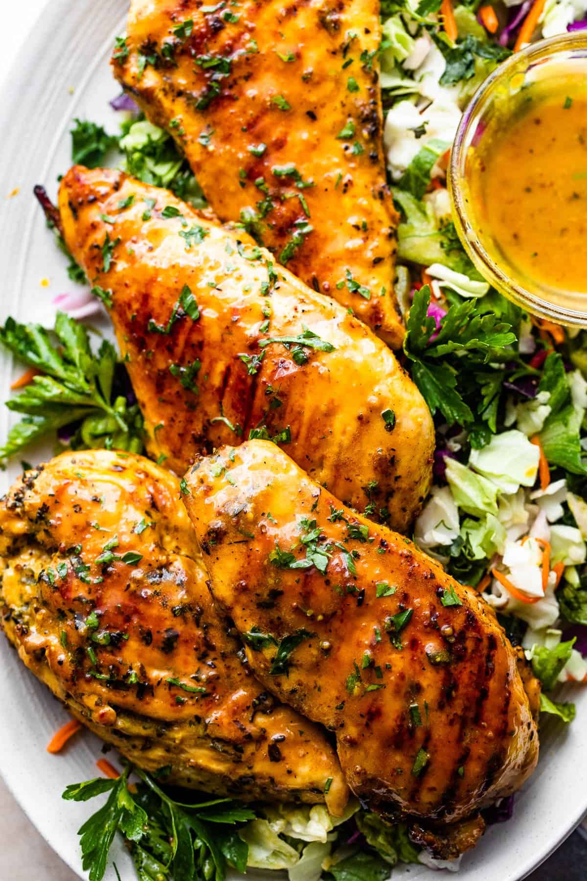 four grilled honey mustard chicken breasts served over a bed of lettuce