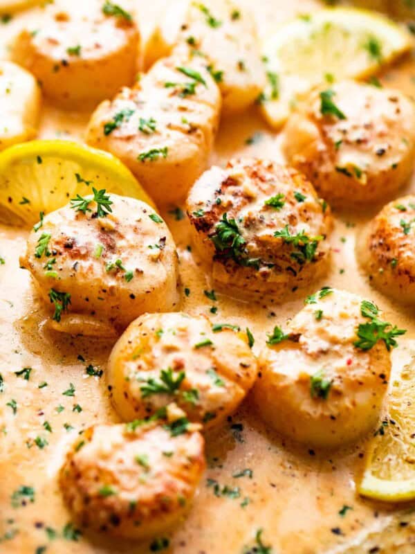 side shot of scallops cooking in a lemon cream sauce