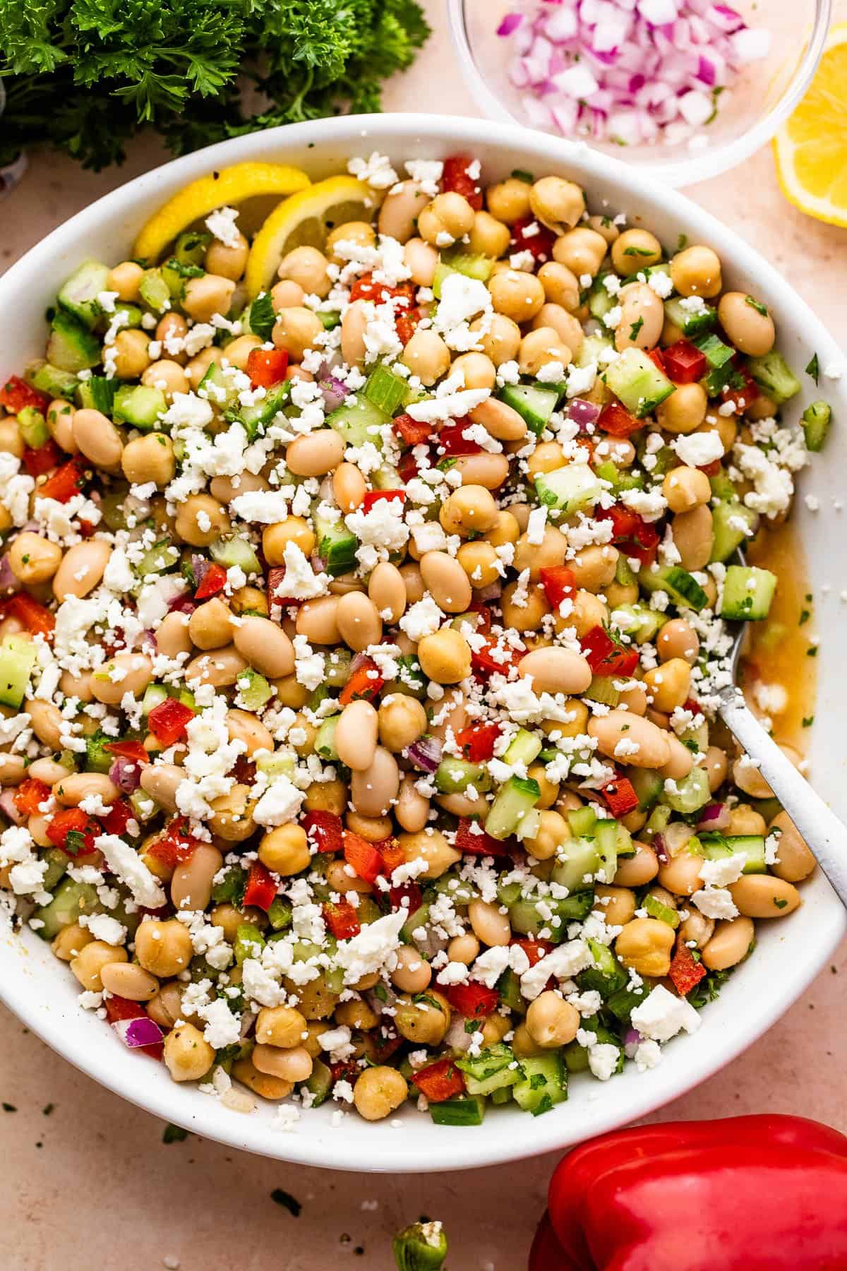 overhead shot of a white salad bowl with chickpea salad topped with crumbled feta cheese