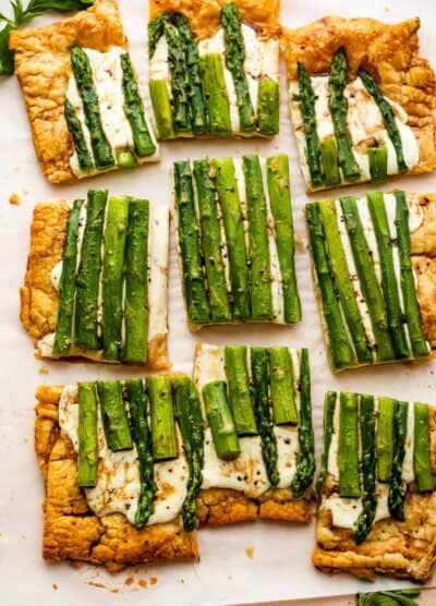 cheesy asparagus puff pastry tart cut up into nine pieces