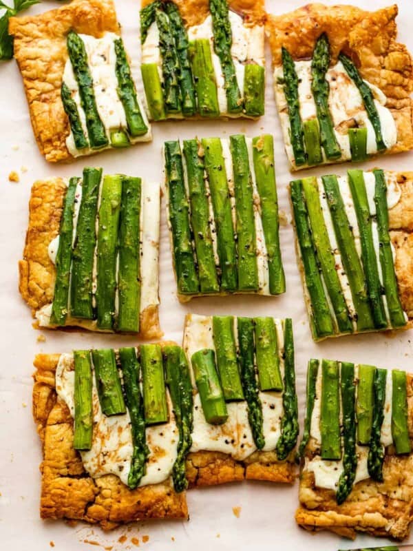 cheesy asparagus puff pastry tart cut up into nine pieces