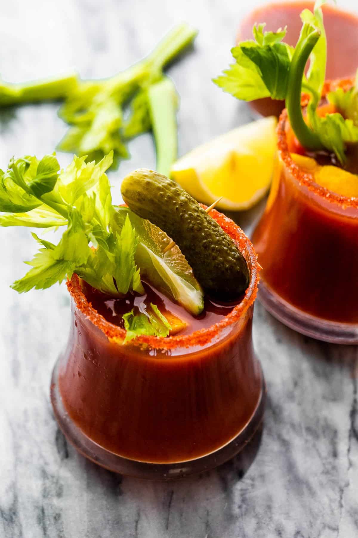 Bloody Mary cocktail garnished with pickles and celery sticks