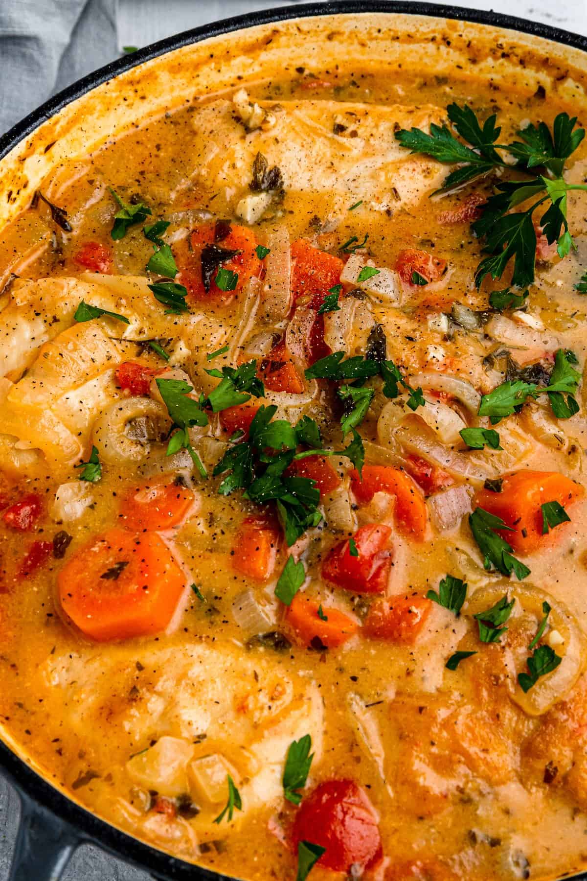 A Pot of Chicken Paprikash Garnished with Fresh Herbs and Cracked Black Pepper