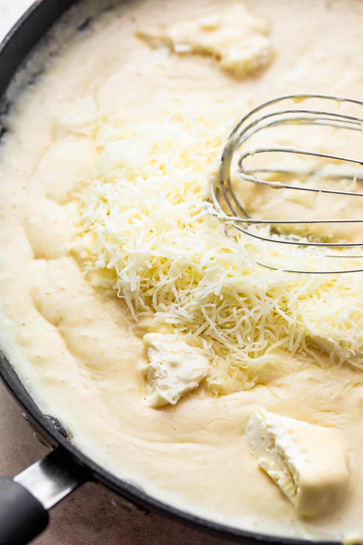 making a creamy cheese sauce in a skillet