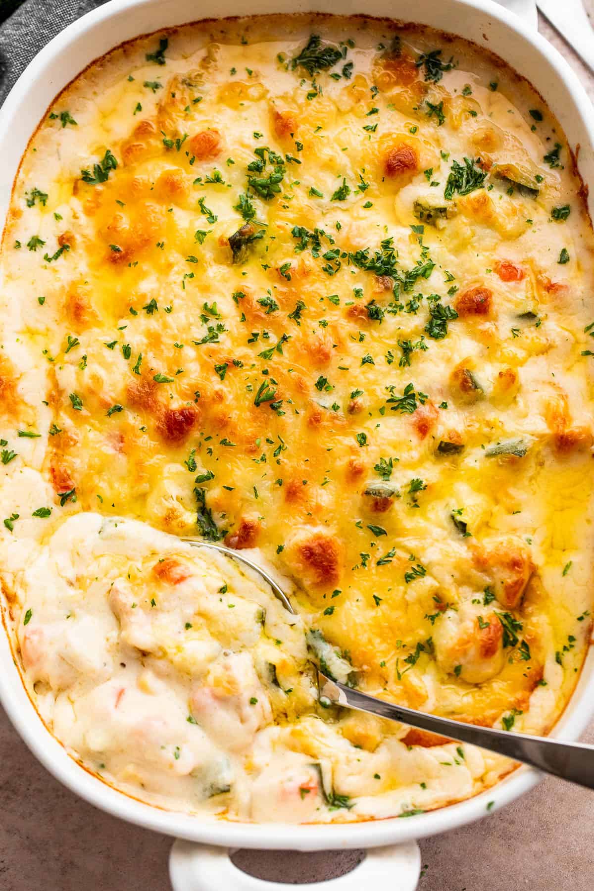 overhead shot of a cooked cheesy chicken zucchini casserole in a baking dish