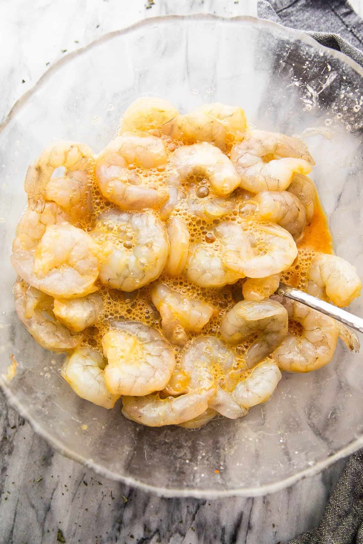 marinating shrimp in a glass bowl