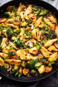 preparing hunan chicken in a black skillet