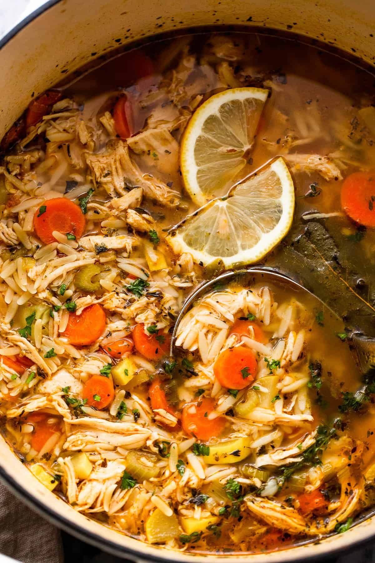 overhead shot of chicken orzo soup in a dutch oven