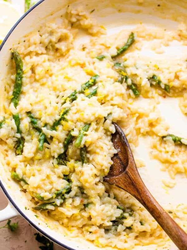 wooden spoon stirring through cooked risotto with asparagus