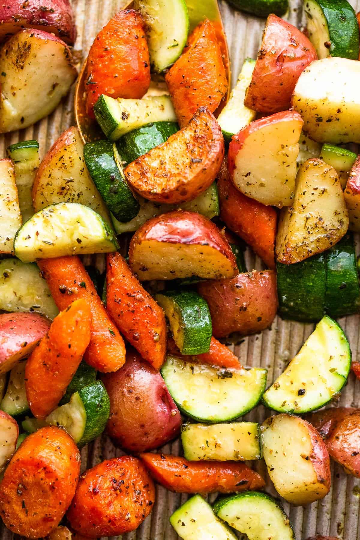 up close shot of cut up carrots, potatoes, and zucchini