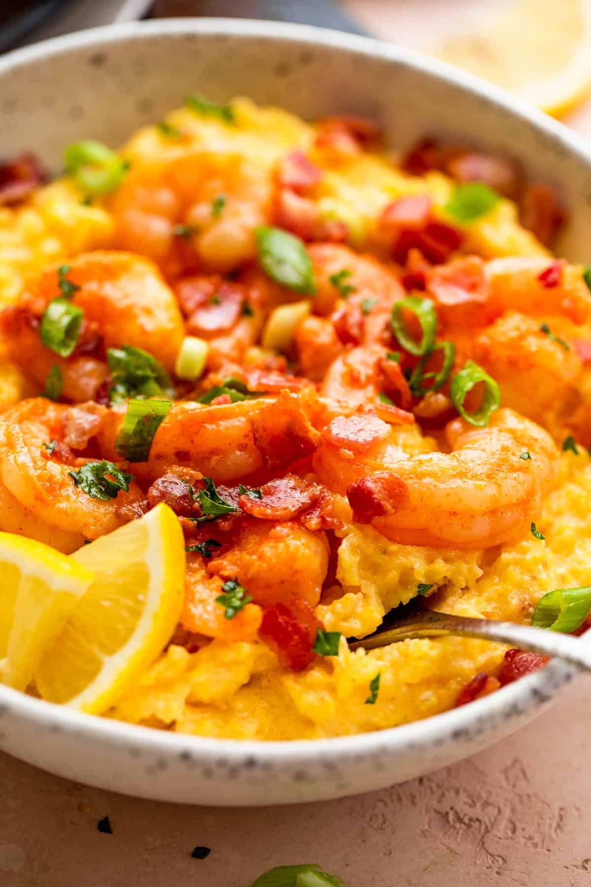 side view of a bowl with slow cooker grits topped with shrimp, bacon, and green onions