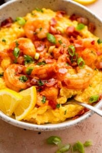 side view of a bowl with slow cooker grits topped with shrimp, bacon, and green onions