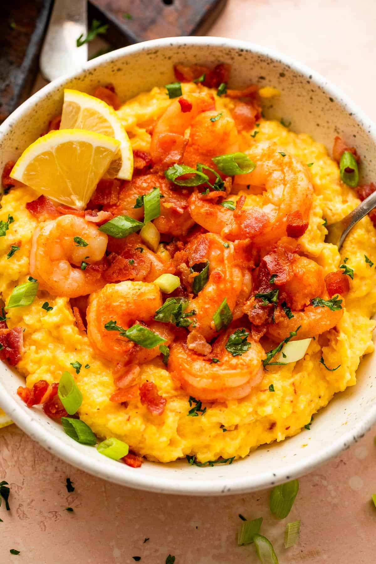 overhead shot of a bowl with slow cooker grits topped with shrimp, bacon, and green onions