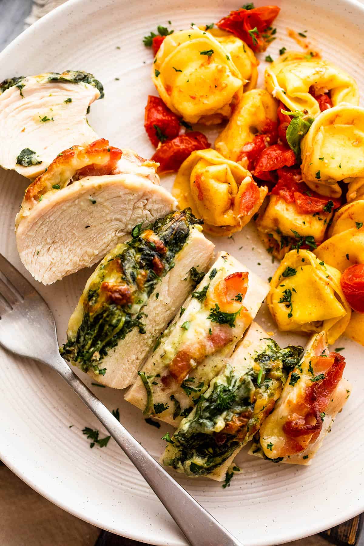 Plate with Spinach and Bacon Stuffed Chicken Breast served with tortellini pasta