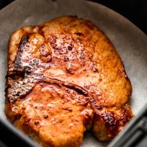 cooked bone in pork chop in an air fryer basket