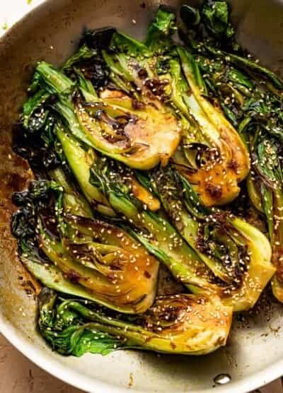 pan fried halved baby bok choy topped with soy dressing and sesame seeds