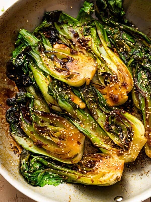 pan fried halved baby bok choy topped with soy dressing and sesame seeds