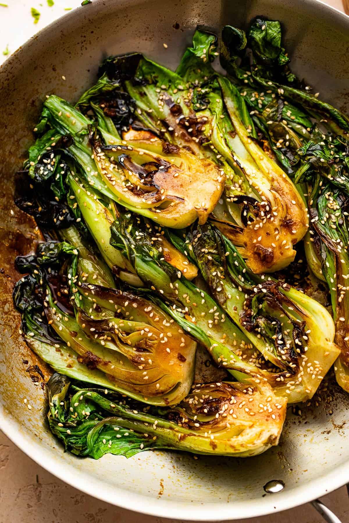 pan fried halved baby bok choy topped with soy dressing and sesame seeds