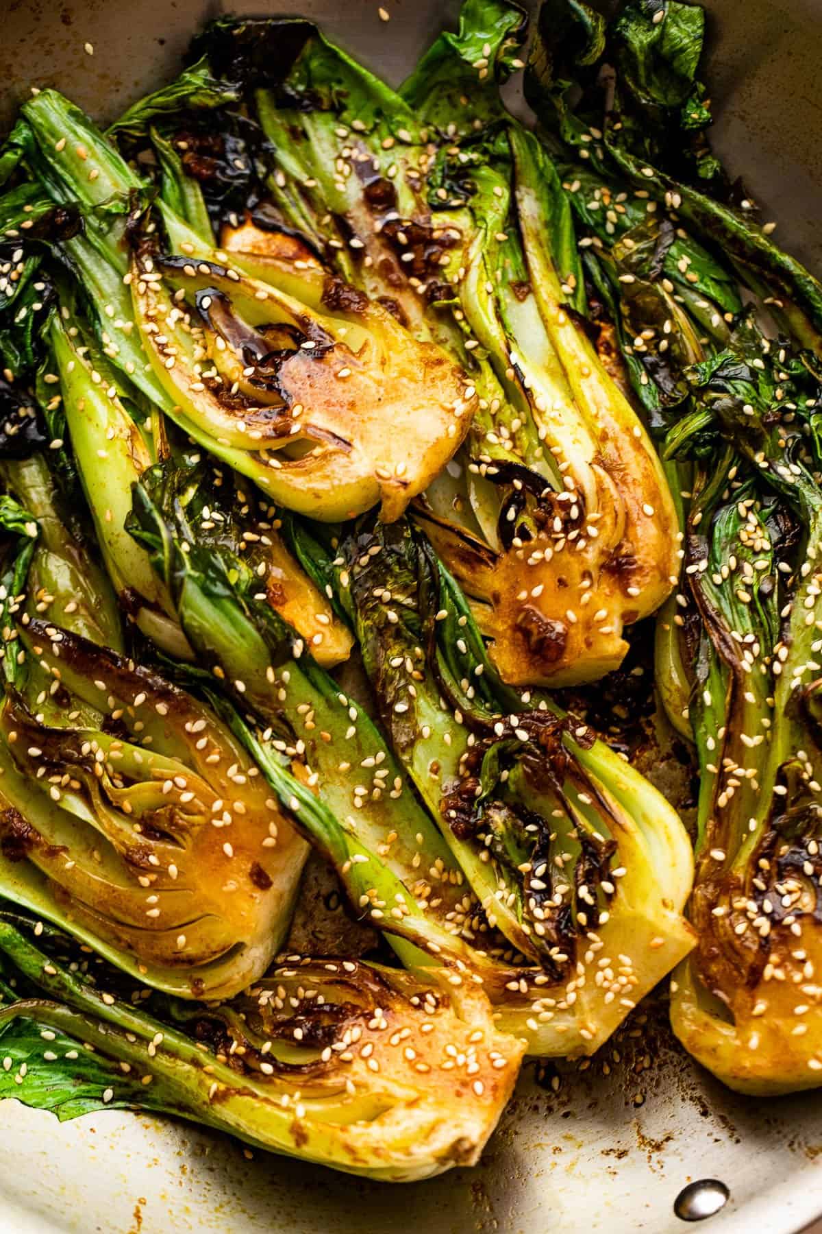 pan fried halved baby bok choy topped with soy dressing and sesame seeds