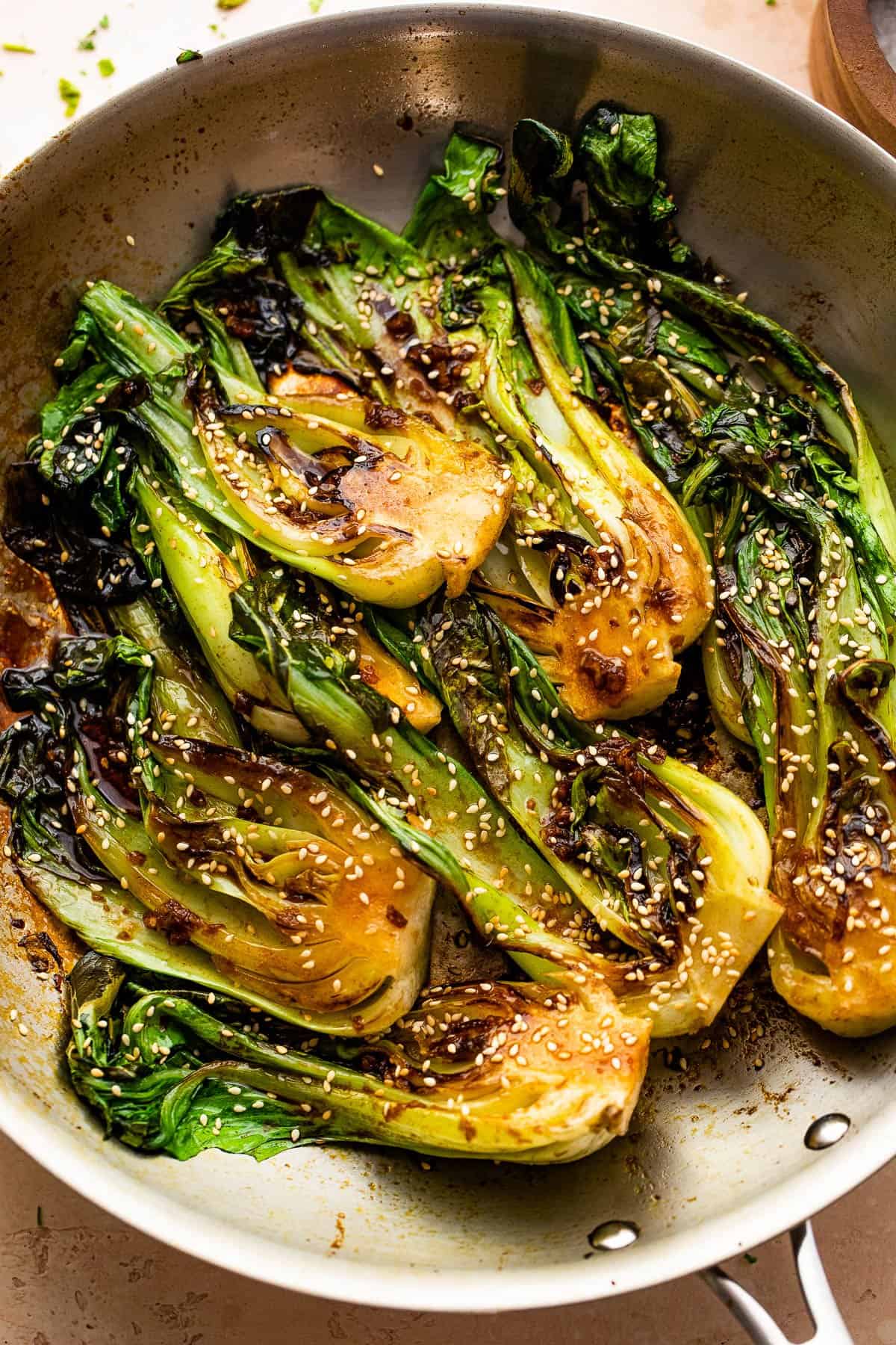 overhead shot of pan fried halved baby bok choy topped with soy dressing and sesame seeds