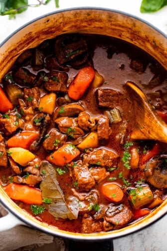 overhead shot of a white dutch oven filled with guinness beef stew.